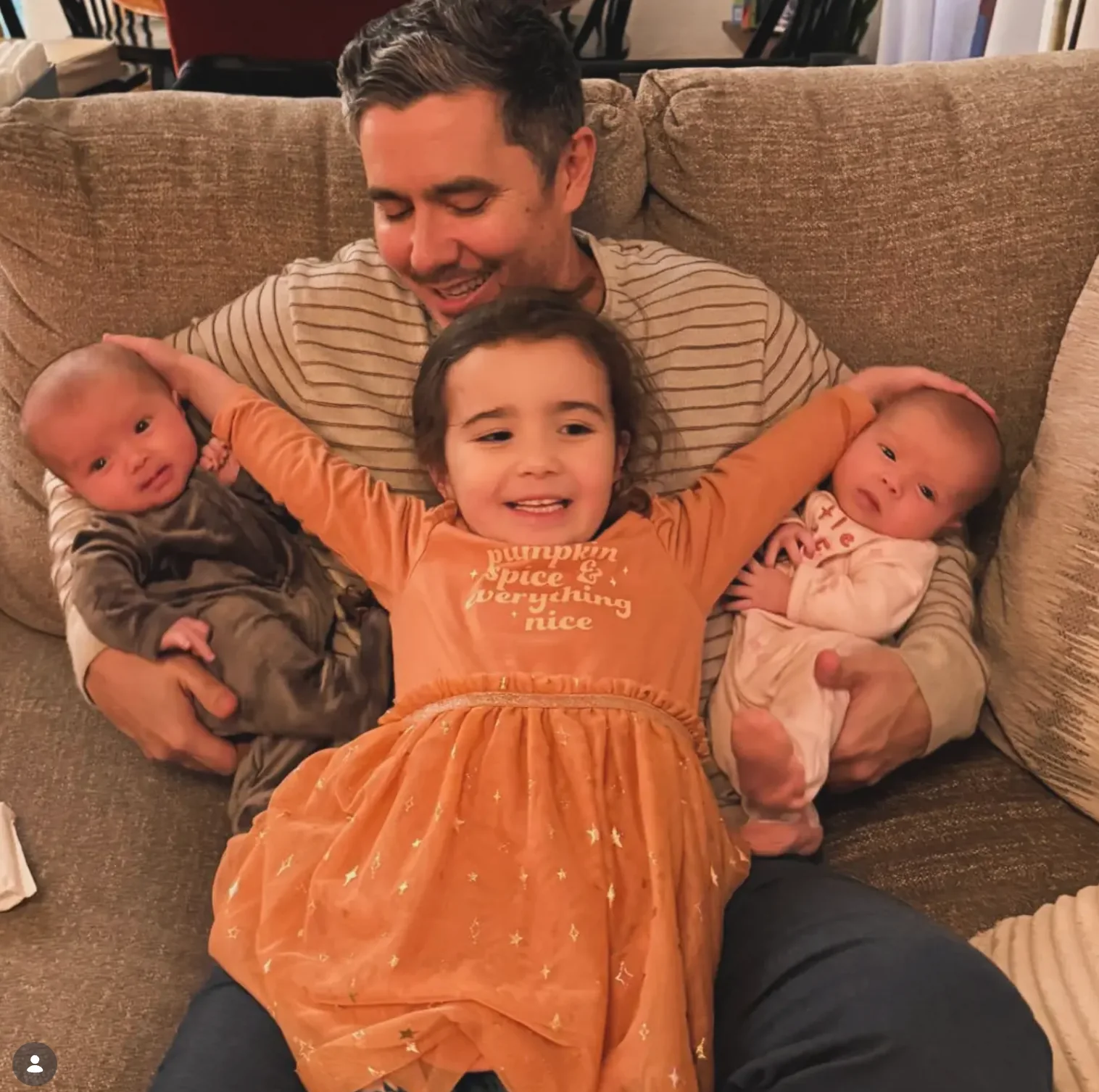 A father with his three daughters on the couch